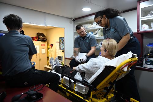 Paramedic students assist a patient in KCC ambulance simulator