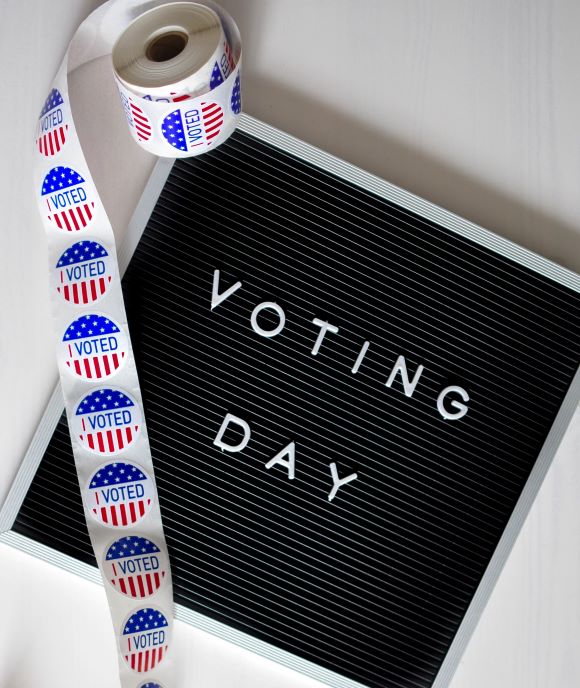 I Voted stickers and board that says "Voting Day"
