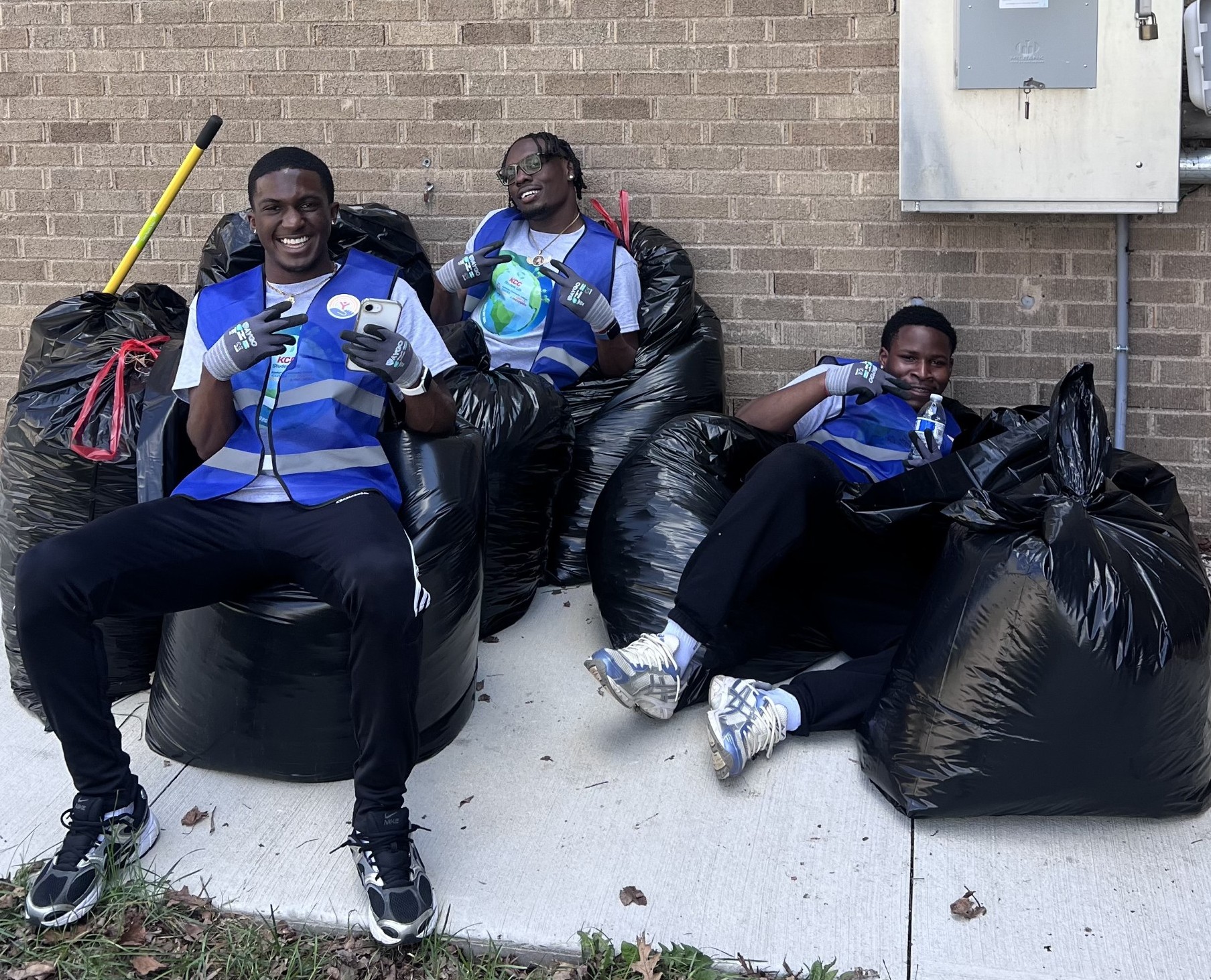 Students rest among the garbage bags from United Way Day of Action for Earth Day.