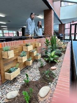 Hort Club officers Dakota Donaldson and Sophia Steelman-Teach pose with interiorscape at Kankakee Community College Riverfront Campus