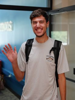 Male student waving