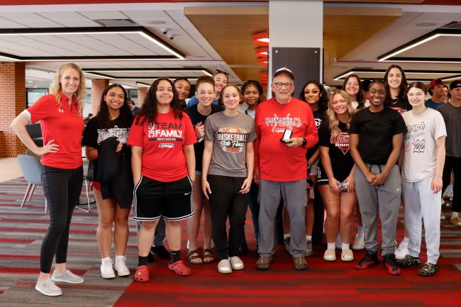 Roy Cordes, "The Voice of the Cavaliers" with KCC's women's basketball players and coach Casey Meister