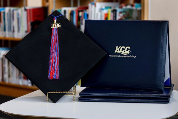 A photo of a graduation cap with a tassel displaying "2026" next to a diploma cover